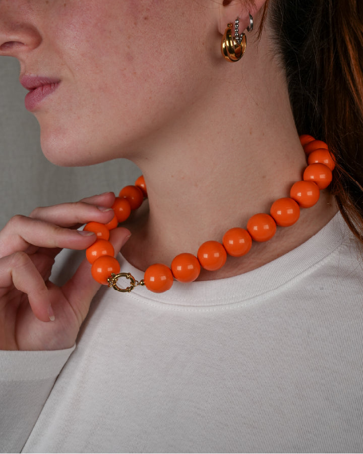 grote grove kralen ketting in fel oranje met een frontclaspsluiting in het goudkleurig