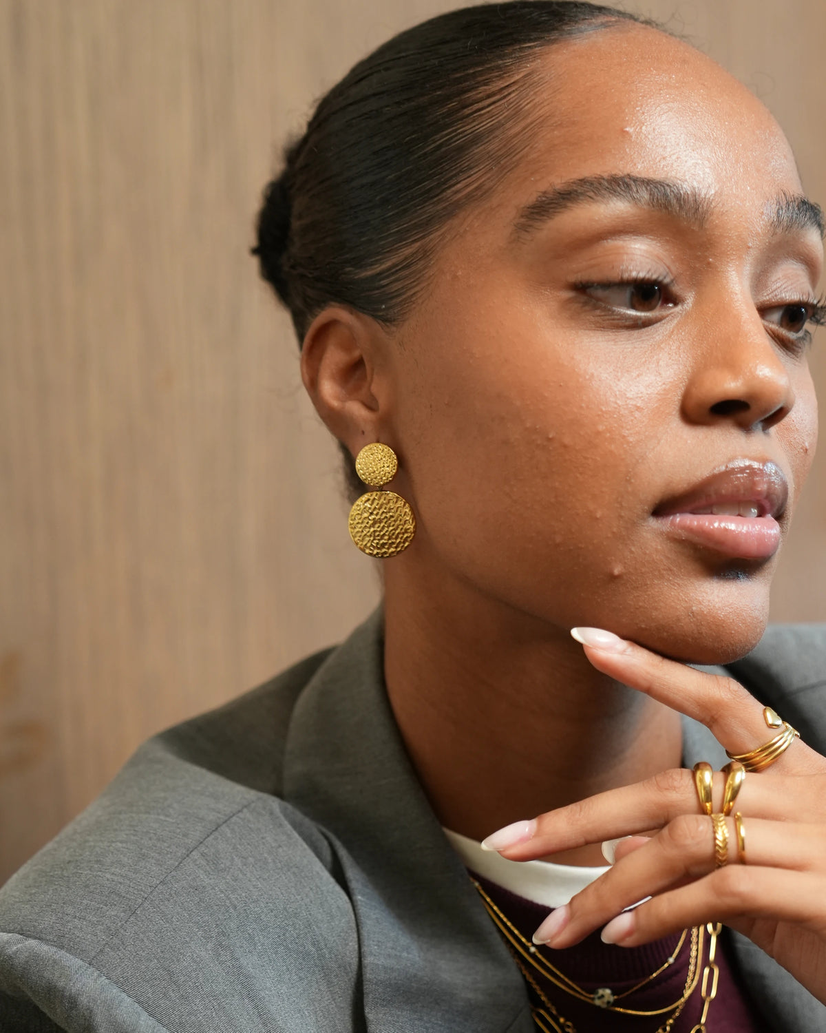 model met oorbellen in goudkleur met een groot en klein rondje met textuur