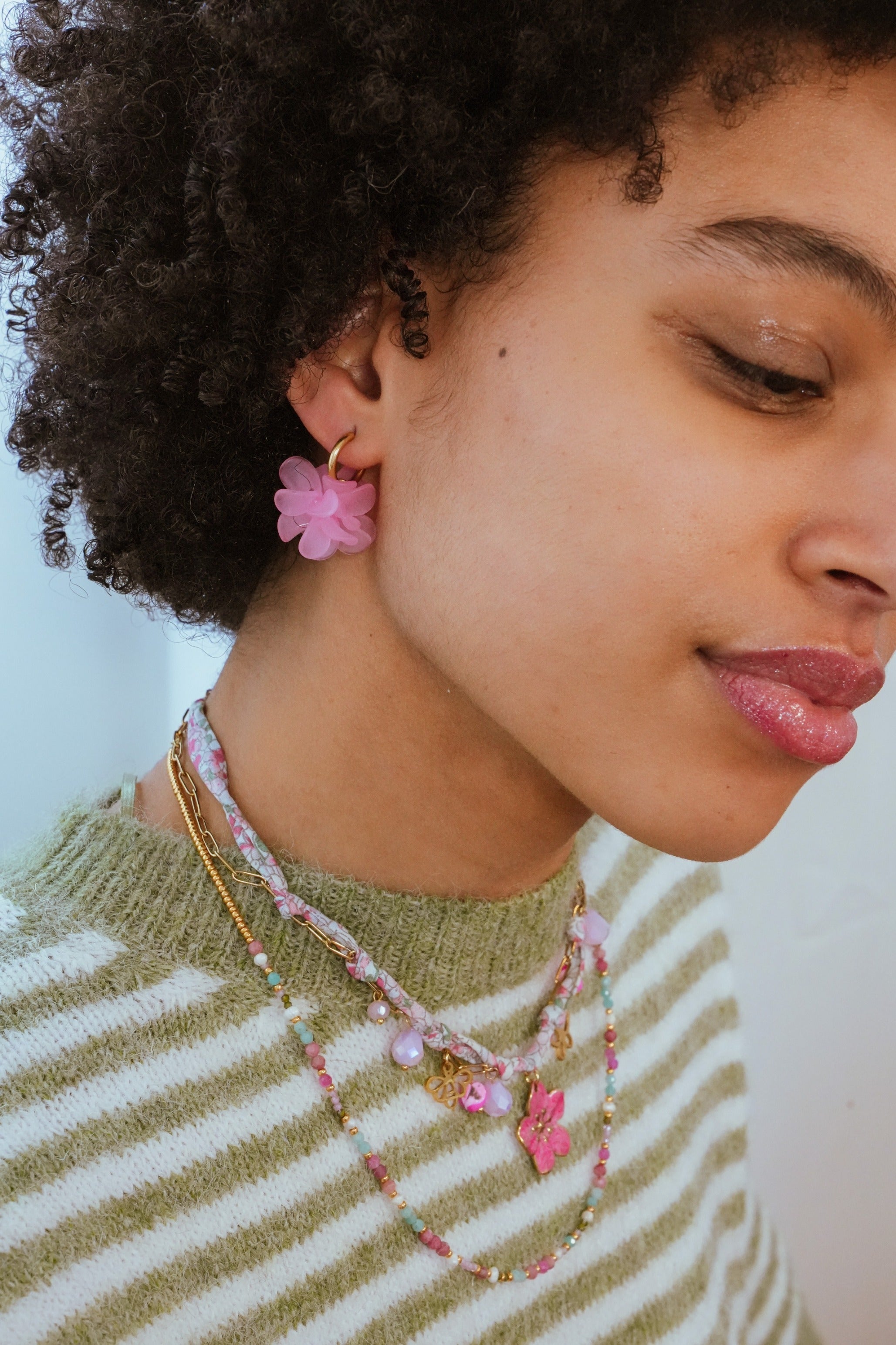 Model met roze bloemen oorbellen in natuurlijk licht