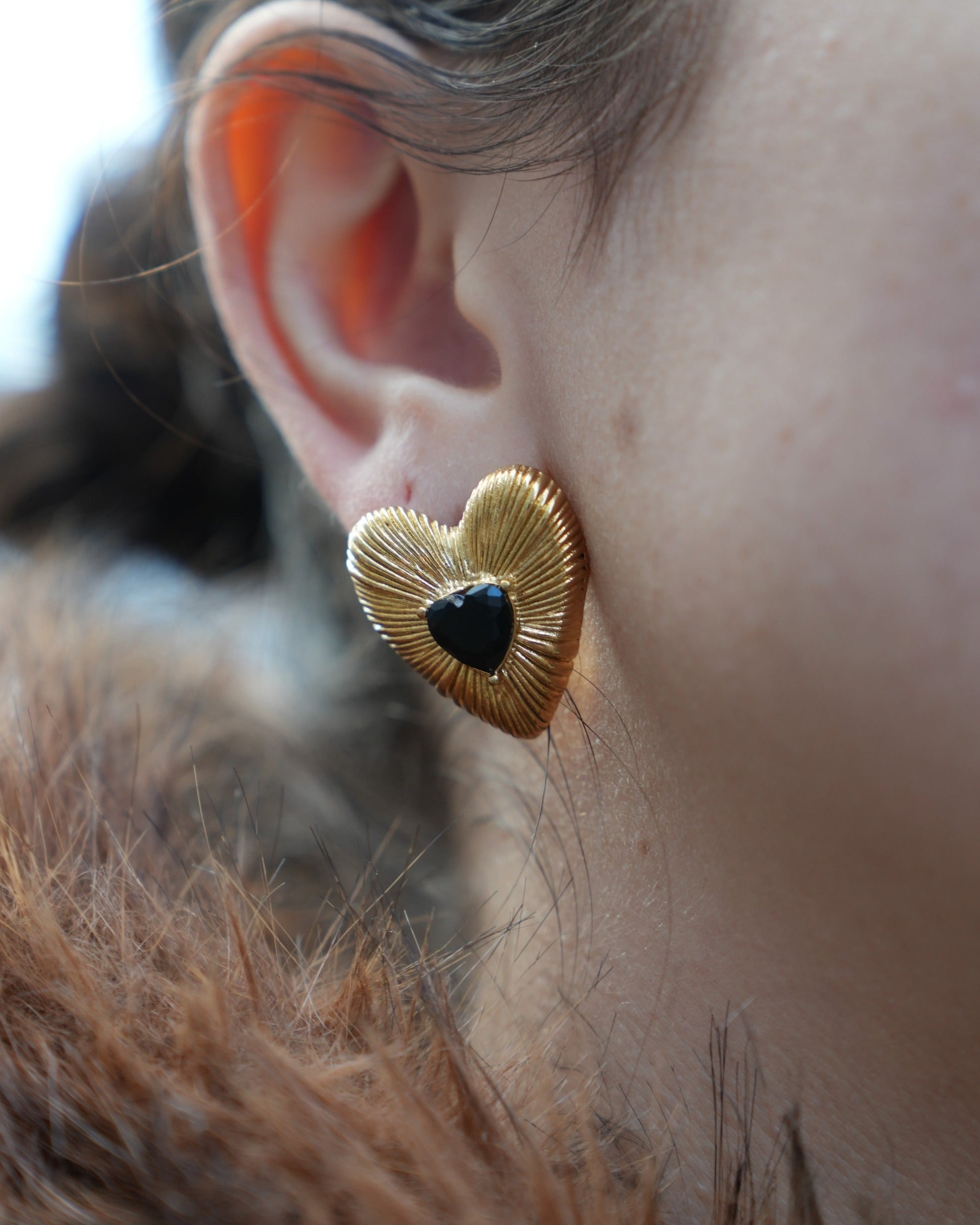 hartjes oorbellen met textuur in het goudkleurig met een zwart hartje in het midden