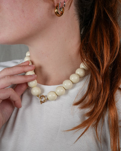 grote grove kralen ketting in wit beige met een frontclaspsluiting in het goudkleurig