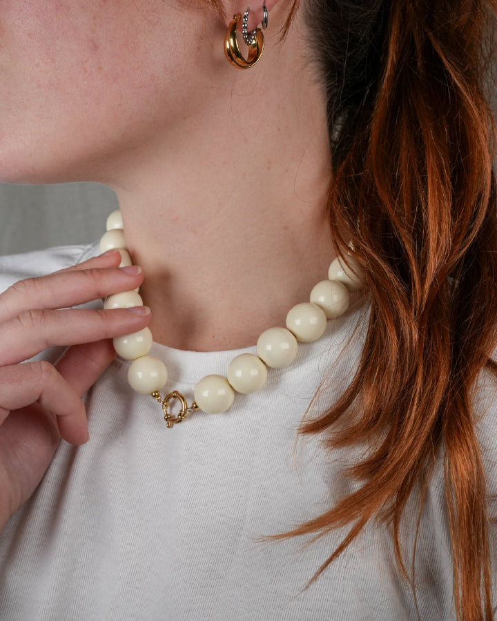grote grove kralen ketting in wit beige met een frontclaspsluiting in het goudkleurig