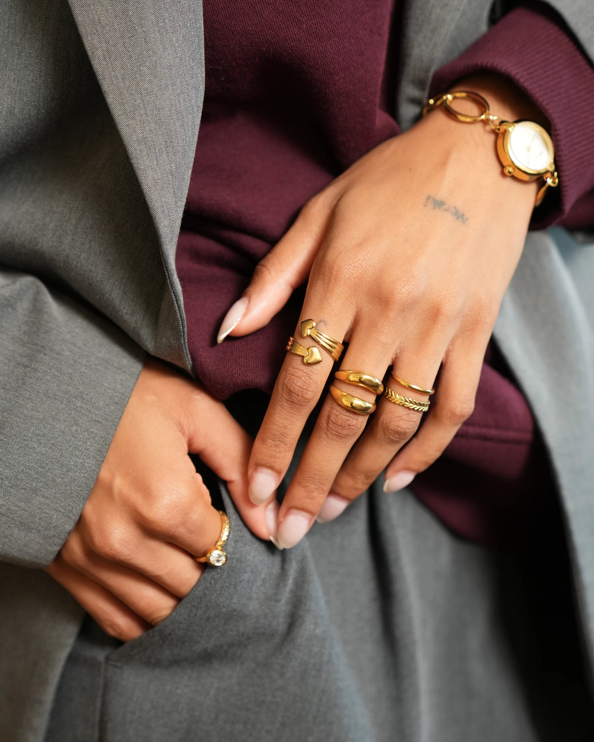 Goudkleurige Dove ring met twee hartjes en open meerdelige band, gedragen aan de vinger
