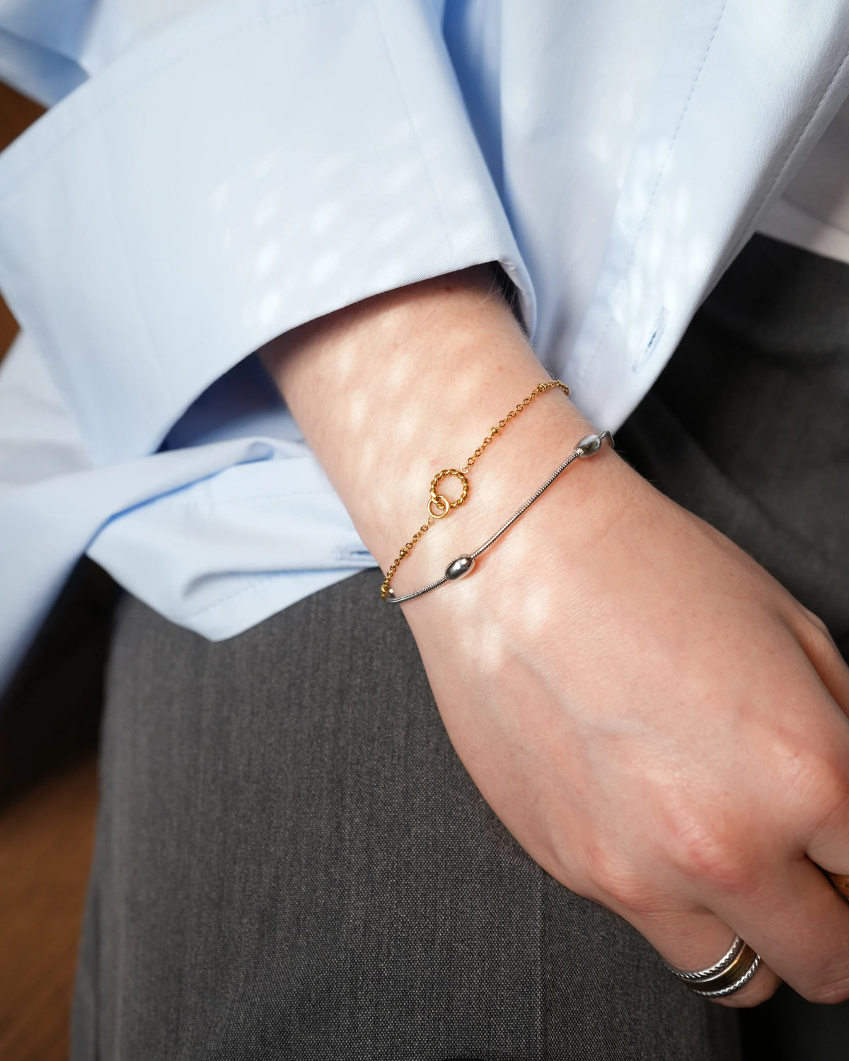 Mavi armband, zilverkleurige met ovale kralen, gedragen om de pols.