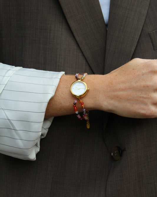 horloge met kralen aan een arm met een blazer