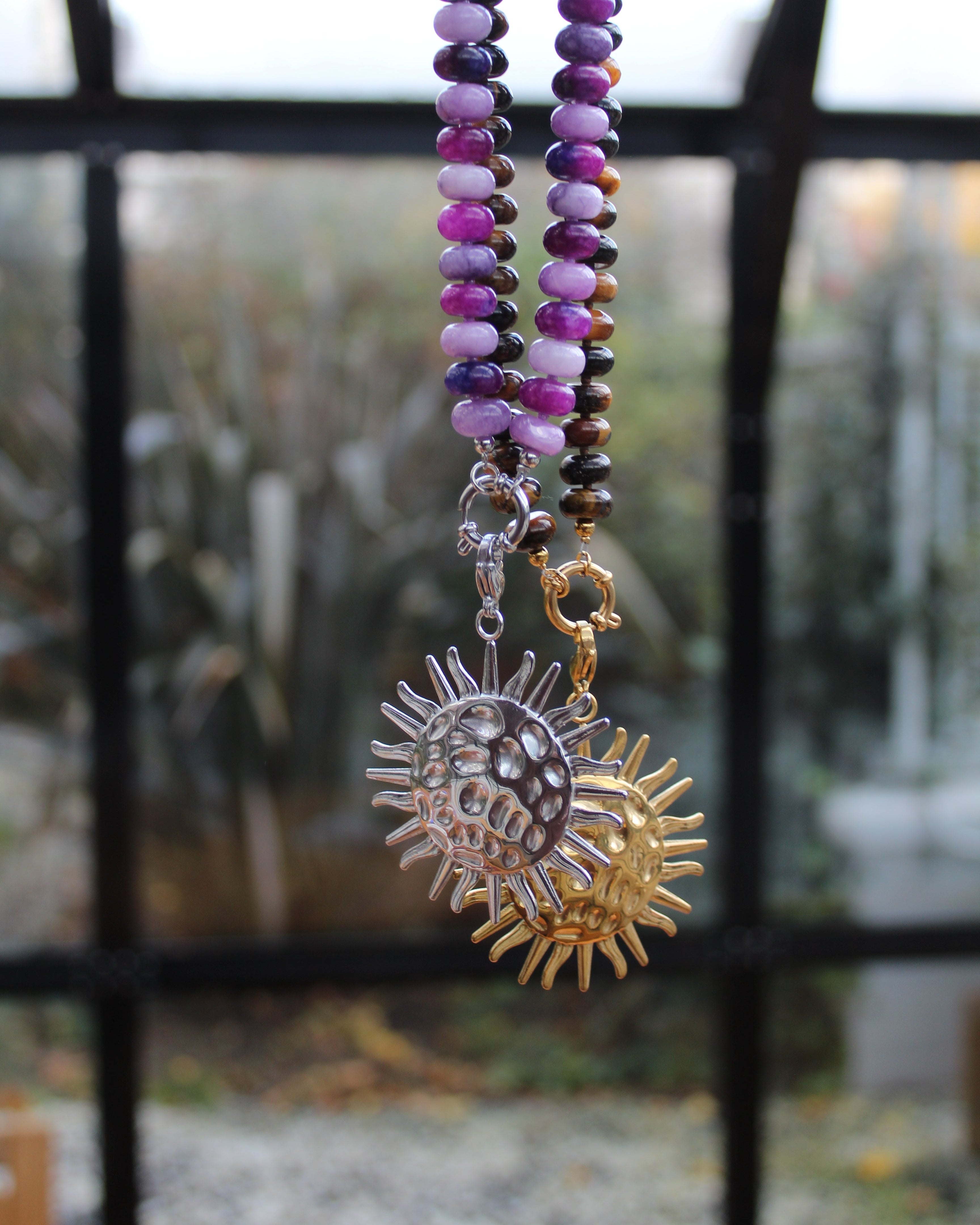 ketting van natuursteen met een zilver en goudkleurige sunflower bedel